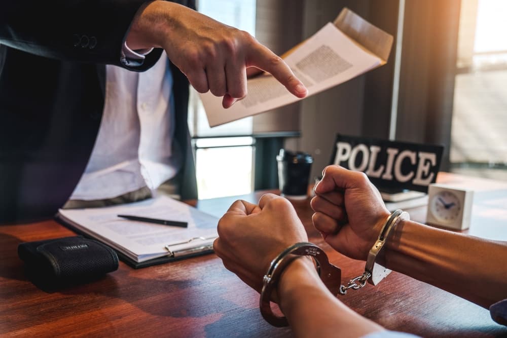 A criminal defense attorney discussing case with client in police officer room