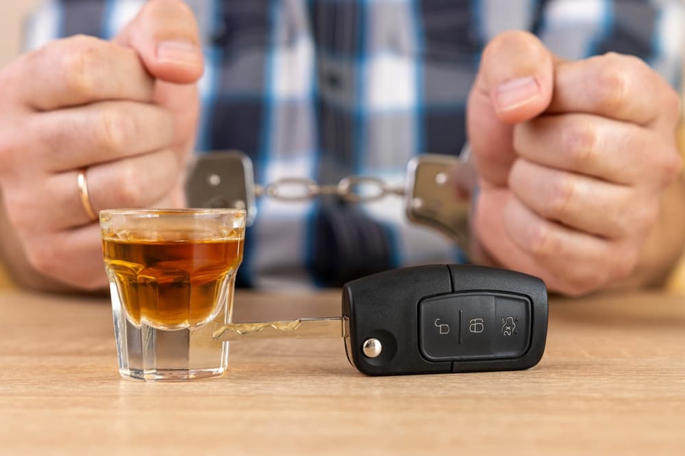 A glass of alcohol and car keys. 