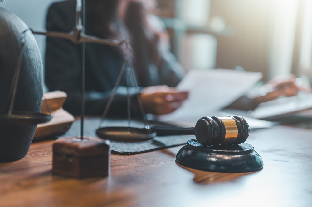 Attorney reviewing legal documents beside gavel and scales of justice in a Savannah law office.
